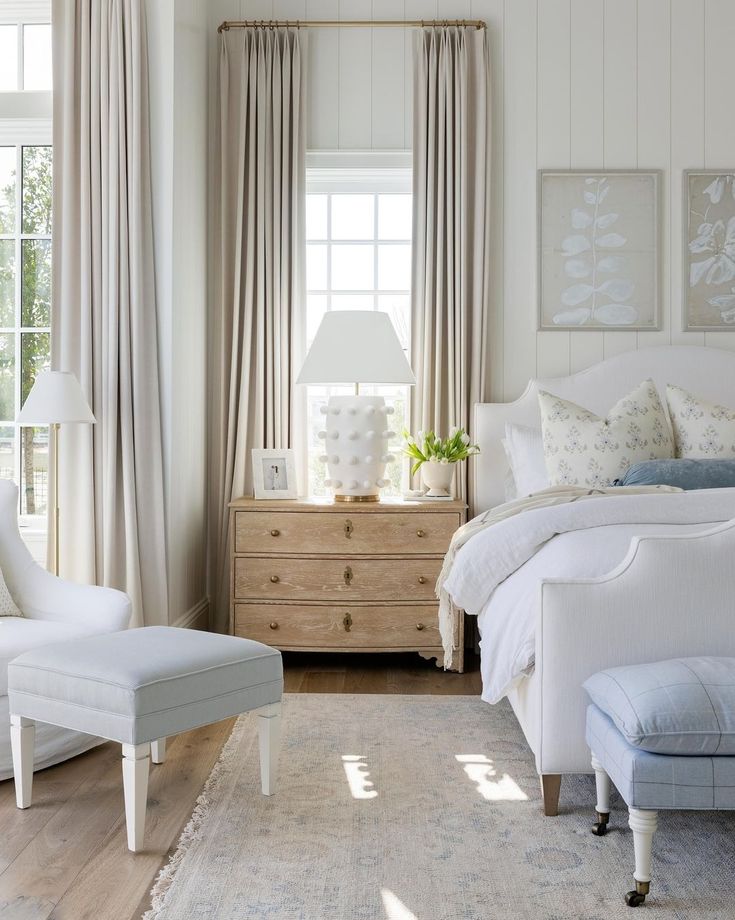 a bedroom with white furniture and curtains on the windowsill