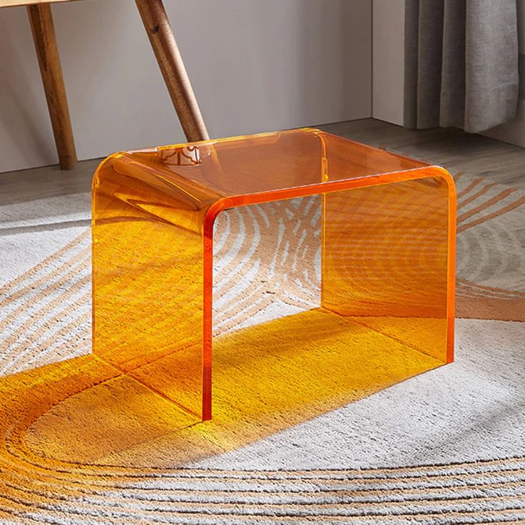 an orange table sitting on top of a white rug