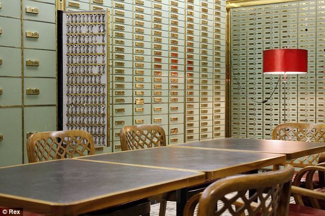 a room filled with lots of wooden tables and chairs next to mailboxes on the wall