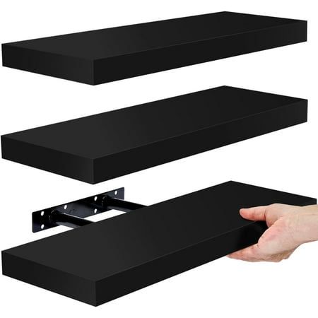 two black shelves are shown with one being held by a hand