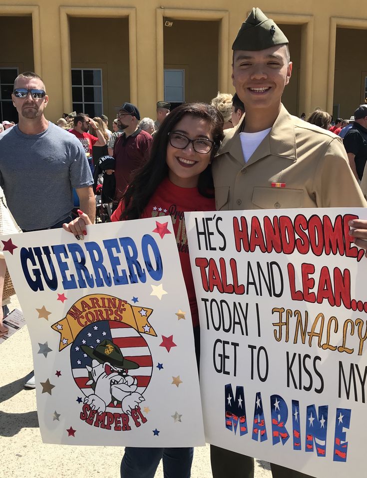 two people holding up signs in front of a building with other people standing behind them