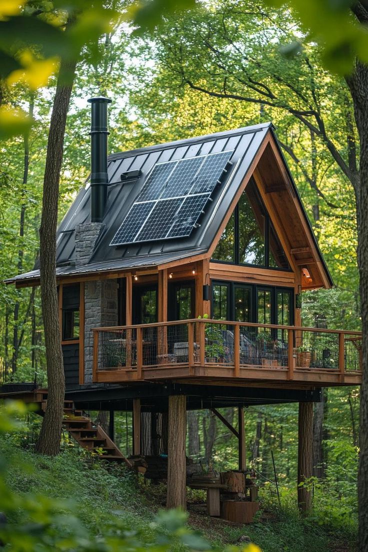 a small cabin in the woods with a solar panel on it's roof and balcony