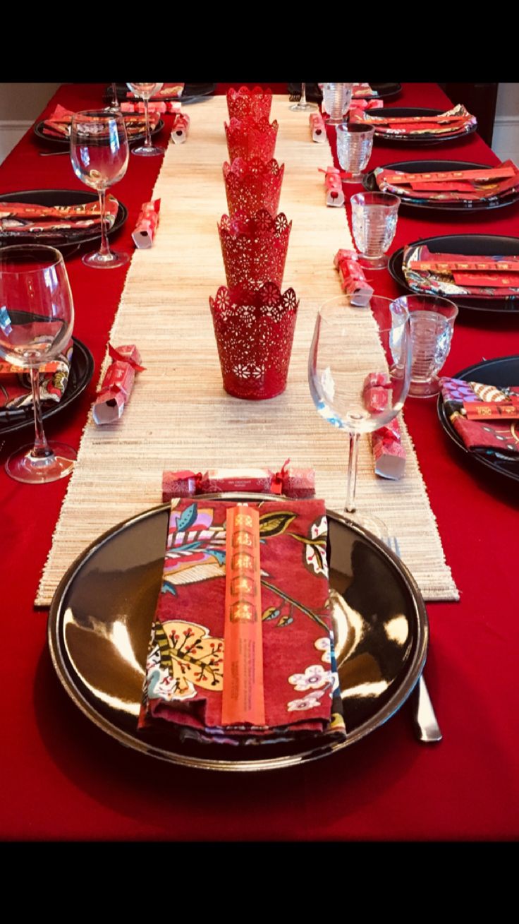 the table is set with red napkins and place settings for an elegant dinner party