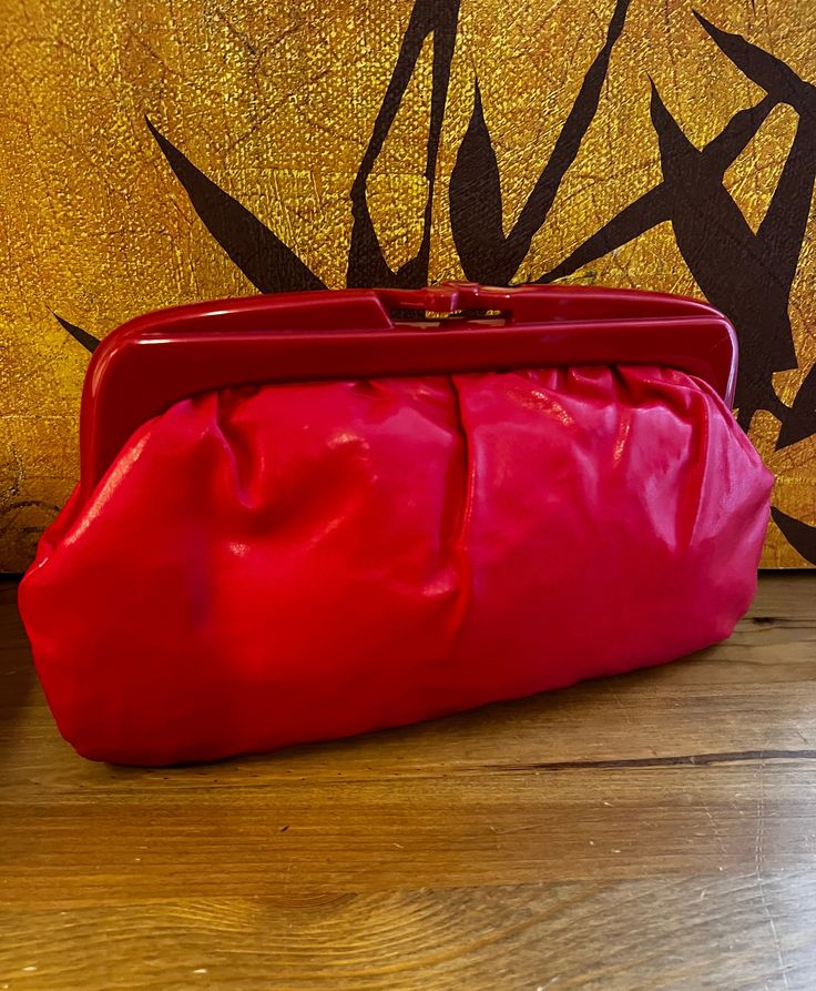 Welcome to LeGossipFindz! Perfect bright red clutch or shoulder bag for a night out. Designed in red vinyl with a hard plastic top closure. Lined in red fabric with one small pocket, and shoulder strap tucks inside. Gathers slightly at the top of the bag. Label-Made in Hong Kong Measurements are in inches. L-11" H-6" D-4" Good  vintage condition. Slight discolour on the inside metal frame. Red Clutch Shoulder Bag For Events, Red Clutch Evening Bag For Shopping, Red Clutch Evening Bag With Removable Pouch, Red Crossbody Clutch For Party, Red Pouch Clutch For Evening, Retro Red Formal Bag, Red Retro Formal Bag, Red Shoulder Bag With Removable Pouch For Party, Red Clutch With Removable Pouch