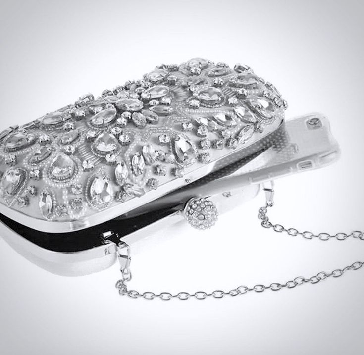 Complete your stunning bridal look with the perfect handbag! Practical and stylish, this evening clutch features rhinestones and pearls swirling in an eye-catching design. Color is a soft gray with silver metal trim. Comes with a removable shoulder chain. Dimensions - Length: 6.25" (approx. 16cm); Height: 4" (approx.10cm); Width: 2" (approx. 5cm). Silver Clutch With Pearl Handle, Glamorous Silver Evening Bag With Pearl Handle, Luxury Silver Evening Bag With Pearl Handle, Luxury Silver Bag With Pearl Handle, Silver Evening Clutch With Pearl Handle, Silver Clutch With Pearl Handle For Events, Elegant Silver Clutch With Pearl Handle, Luxury Silver Clutch With Rhinestones, Elegant Silver Bag For Wedding Guest