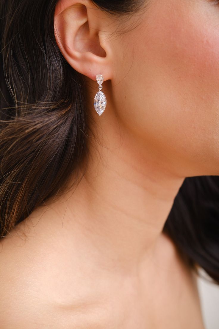 a woman wearing a pair of earrings with diamonds on the back of her neck and behind her ear