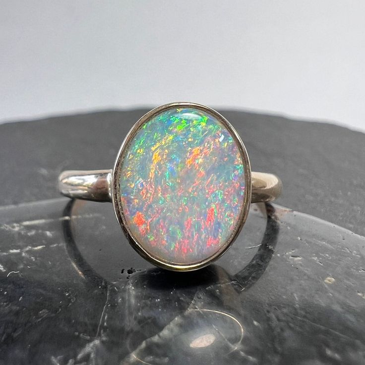 Exceptional Australian opal 14k gold statement ring with nice size oval stone from the Coober Pedy field. Currently US size 7 3/4 (select size at checkout) Australian Opal - 1.38 carats, 10.83mm x 8.75mm x 2.41mm One of kind, hand made. All of our creations are made out of 14K Gold (Yellow, White, Rose) or 925 Sterling Silver, None are filled or electroplated.  All of our stones are Nature-made, therefore some natural flaws may be present. Hand crafted in the We Work Gems Shop in Washington State. Size and weight are approximate. Please feel free to ask any questions. Back to our shop https://www.etsy.com/shop/weworkgems 24D12 Oval Opal Rings With Polished Finish, Classic Ethiopian Opal Ring In Oval Shape, Elegant Untreated Oval Opal Ring, Elegant Oval Untreated Opal Ring, Oval Cabochon Opal Ring With Polished Finish, Polished Opal Oval Cabochon Ring, Polished Opal Ring In Oval Cabochon Shape, Oval Opal Cabochon Ring, Opal Oval Cabochon Ring With Polished Finish