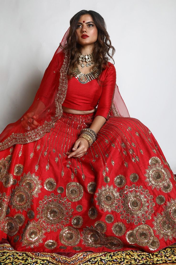 Red dupion silk lehenga with zari and sequins hand embroidered chakra motifs. Comes with a padded blouse and an organza scalloped dupatta.
Component: 3
Pattern: Embroidered
Type Of Work: Zari, Sequins
Neckline: V Neck
Sleeve Type: Three quarter
Fabric: Lehenga and Blouse: Dupion Silk, Dupatta : Organza 
Color: Red
Other Details: 
Closure : Blouse : Back with Hook and Eye, Lehenga : Opening on the side with Zip and Hook along with Drawstring.
Occasion: Wedding - Aza Fashions Red Dola Silk Lehenga For Eid, Red Kundan Lehenga For Eid, Red Chanderi Lehenga With Intricate Embroidery, Red Art Silk Lehenga For Eid, Choli With Intricate Embroidery For Navratri Celebration, Red Embroidered Sets For Navratri, Bollywood Style Festive Raw Silk Lehenga, Red Silk Lehenga For Festivals, Festival Choli With Intricate Embroidery For Celebration