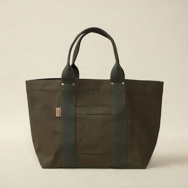 Heavy weight canvas tote 21.6" x 6.7" x 12.6" made in Japan Threadline is a Japanese-manufactured line of heavy canvas bags designed for everyday use. Large Capacity Duck Canvas Bag For On-the-go, Khaki Canvas Bag For On-the-go, On-the-go Canvas Bag With Reinforced Handles, Khaki Cotton Bags With Leather Handles, Modern Cotton Canvas Bag With Canvas Lining, Khaki Canvas Tote Bag With Canvas Lining, Practical Cotton Shoulder Bag With Leather Handles, Khaki Canvas Tote Bag, Rectangular Cotton Weekender Bag With Pockets