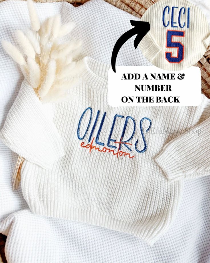 Get your little one ready for playoff hockey season with our gender-neutral, thick white knit sweater featuring a vintage inspired embroidery on the chest. Designed with a slightly oversized fit for maximum comfort, this sweater is perfect for cheering on your favorite team in style. Made with high-quality cotton, it's not just fashionable but also cozy, keeping your little fan warm throughout the game. Add a touch of team spirit to your child's wardrobe with this must-have sweater! Want a diffe White Long Sleeve Sweater For Game Day, White Sweatshirt For Game Day In Winter, White Winter Game Day Sweatshirt, White Crew Neck Sweater For Game Day, White Collegiate Sweater For Fall, Oversized White Sweater For College, Sporty White Sweater With Embroidered Logo, White Tops With Embroidered Logo For Game Day, White Letter Embroidery Sweater For Winter