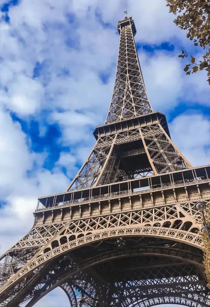 the eiffel tower in paris, france under a blue sky with wispy clouds