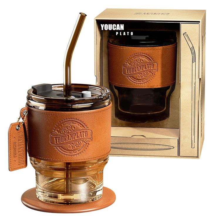 a glass jar with a straw in it and a brown leather strap around the lid