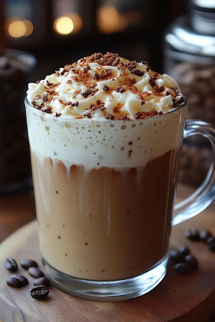 there is a cup of coffee with whipped cream on top and chocolate chips around it