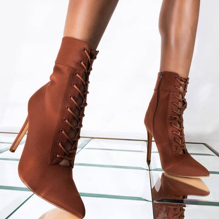 Cognac Stiletto Booties Are Too Good To Snooze On. The Mid-Calf Ankle Bootie Features A Lace Up Front, A Zipper At The Inner Ankle, A Pointed Toe, And A Sky High Stiletto Heel. Easy To Dress Up Or Down, We Especially Love These Boots With A Pair Of High Waisted Cropped Trousers, A Cable Knit Winter Sweater, And A Wide Brim Felt Fedora. Fitted Heeled Boots With Wrapped Heel For Fall, Brown High Heel Lace-up Boots For Party, Fitted Brown Lace-up Boots For Fall, Elegant High Heel Brown Lace-up Boots, Fitted Brown Knee-high Lace-up Boots, Elegant Brown Lace-up Boots With Pointed Toe, Brown Fitted High Ankle Lace-up Boots, Brown Fitted Ankle Lace-up Boots, Fitted High Ankle Brown Lace-up Boots