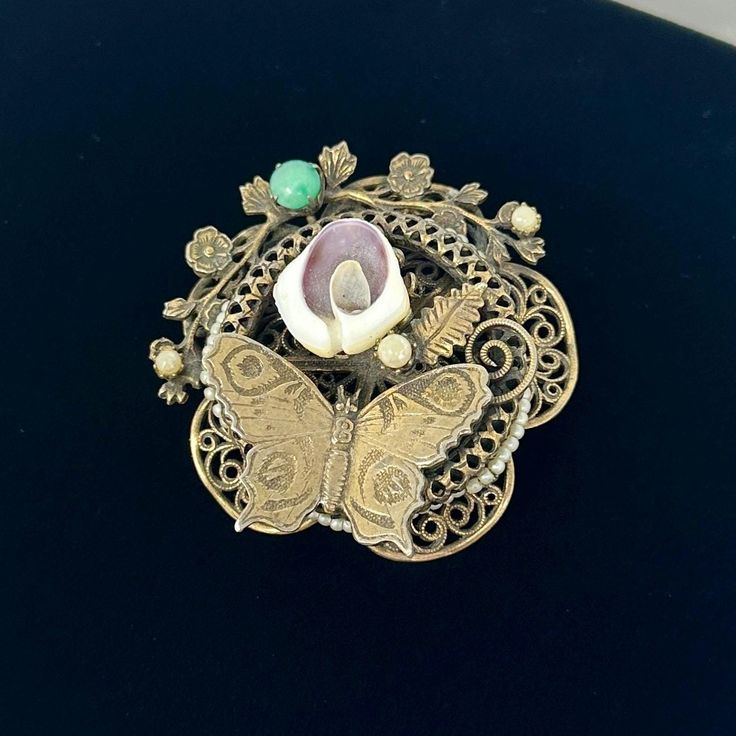 🌼 Such a gorgeous piece.  1940s round brooch, that can be converted to a necklace pedant, gold tone with butterfly, faux pearls, as filigree floral frame.   🌼 Measures: 2 1/8" diameter. 🌼 Condition: good. some wear on the finish. Please see photos for complete condition. To view more vintage jewelry and boxes in my shop, please visit: https://www.etsy.com/shop/TheVintageDaisyVault?ref=seller-platform-mcnav§ion_id=25440304 Antique Gold Victorian Brooch Jewelry, Victorian Antique Gold Brooch Jewelry, Antique Medallion Brooch For Wedding, Antique Medallion Brooch Jewelry, Collectible Gold Filigree Brooches, Gold Filigree Brooches Collectible, Ornate Gold Brooches For Vintage Events, Ornate Gold Locket Brooches, Gold Filigree Brooches For Collectors