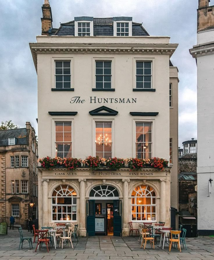 the huntsman hotel is located in an old town square with tables and chairs outside