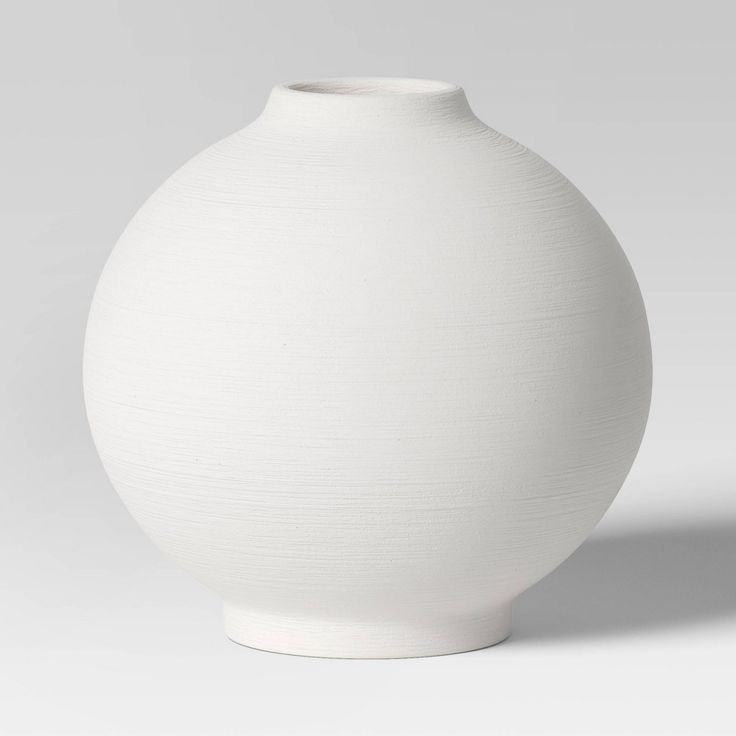 a white vase sitting on top of a table