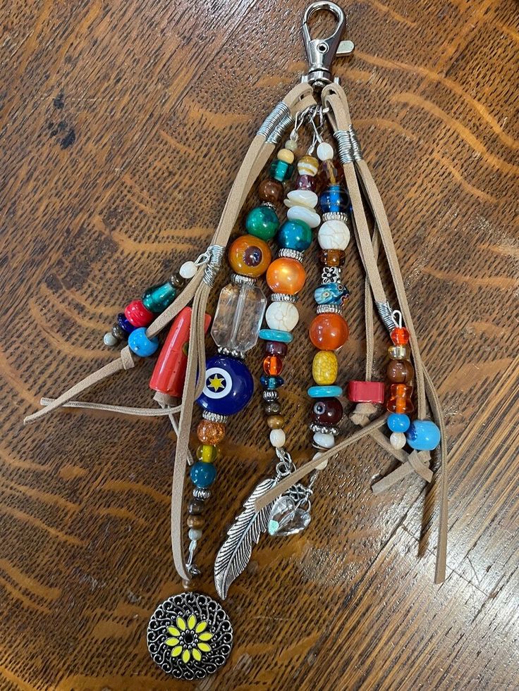 a wooden table topped with lots of beads and charms