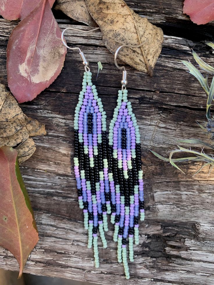 Maggie  clan bird  Elegant celadon (light blue/green), wisteria purple, opal lined light purple, and black earrings.   all earrings are handmade and unique. i use beads that were given to me by my grandmother, recycled, bought locally, or from small businesses. please note, there will be some imperfections.  my earrings are a modern take on traditional design and cherokee clan style.  w o l f: traditional. strong. ornate.  b i r d: simple. petite. feminine.  l o n g h a i r: bohemian. dramatic. free spirited.  w i l d p o t a t o: unique. novel. eccentric.  p a i n t: one-of-a-kind. vivid. bold.  b l u e: classic. timeless. practical.  d e e r: natural. earthly. native.  please allow one-three weeks to ship.  under most circumstances, I will not accept cancellations or returns. please mess Wisteria Purple, Purple Opal, Line Light, D P, Light Blue Green, Black Fringe, Black Earrings, Free Spirited, Fringe Earrings