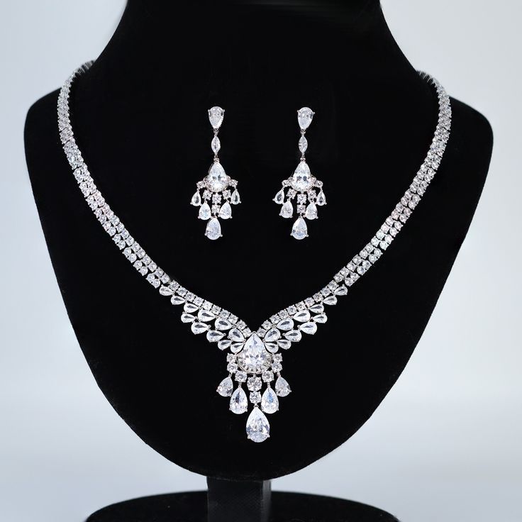 New to our Millennium collection, These beautiful romantic bridal earrings and necklace are made of very fine quality of Swarovski crystals/ Cz diamonds and plated with platinum for your special day! Even we have hard time taking pictures because of their shine 😄 so we want to shine our brides on their special days. Simulated diamonds are also known as diamond simulants and include things like cubic zirconia (CZ), moissanite, and YAG. They can also include some natural clear gemstones like white sapphire, white zircon or even clear quartz. Simulated "diamonds" can be gorgeous but do not possess the chemical and physical properties of actual diamonds, so they generally sell for a relatively low cost. Measurements: The necklace measures about 18 inches long around your neck  the earrings me Fine Jewelry Crystal Bridal Necklace For Wedding, Brilliant Cut Crystal Bridal Earrings In Diamond White, Diamond White Brilliant Cut Crystal Bridal Earrings, Fine Crystal Bridal Necklace For Wedding, Crystal Bridal Necklace For Wedding, White Gold Rhinestone Necklace With Sparkling Stones For Wedding, Dazzling Bridal Necklace With Diamond Accents And Crystal, White Gold Rhinestone Wedding Necklace, Crystal Bridal Necklace With Rhinestones For Anniversary