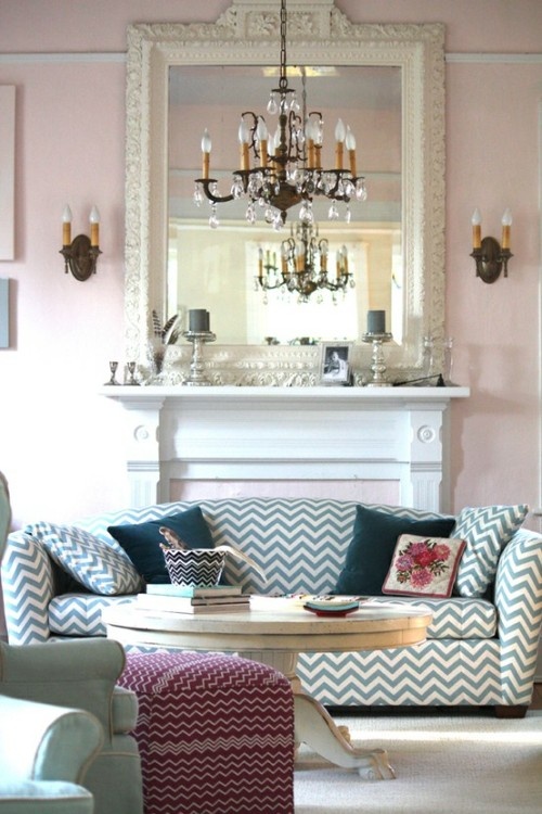 a living room filled with furniture and a chandelier above a fire place in front of a fireplace