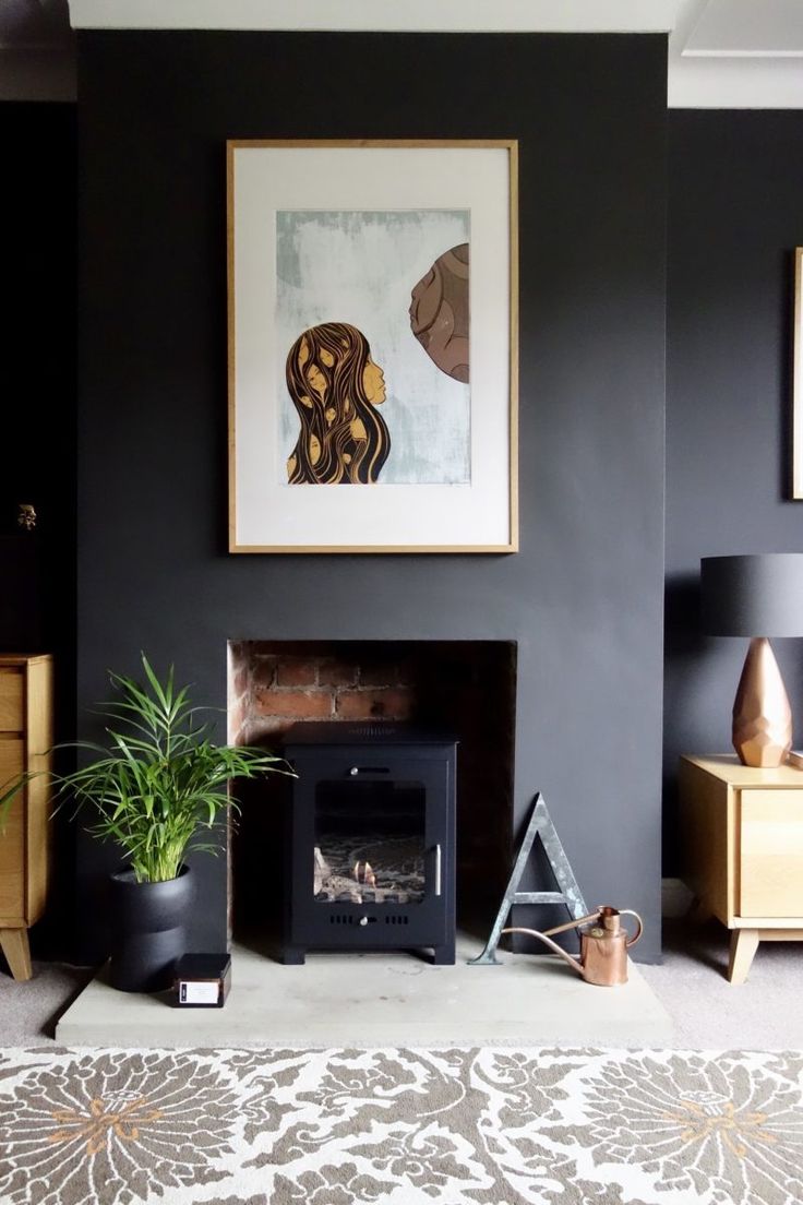 a living room with black walls and pictures on the wall, including a fire place