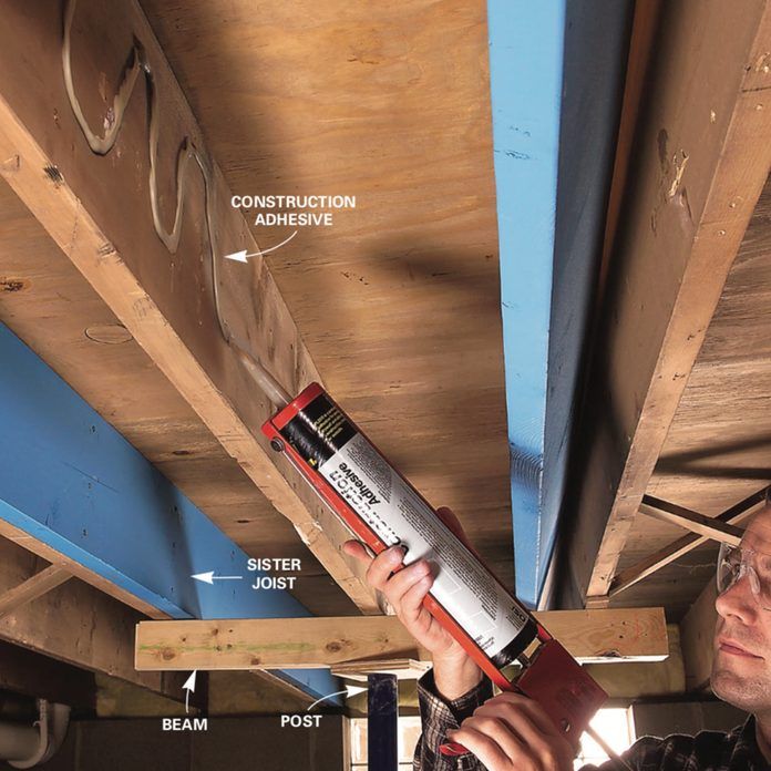 a man is fixing the underside of a garage ceiling with an adhesive tape on it