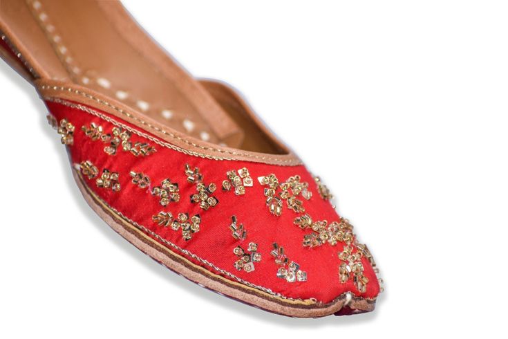 Leena - Red Punjabi Designer Jutti for Ladies with golden embroidery Feel like a star in this exquisite pair of hot red ethnic Indian shoes ready to match your red dress on any occasion. Style: The shoes have been hand embroidered in a minimalist fashion with the most elegant and simple gold bugle bead patterns further accented with a sheen gold thread. The color looks magnificent with embroidery that balances the simplicity giving it a look that will keep you in the limelight all the time wheth Bollywood Style Festive Flats With Round Toe, Bollywood Style Round Toe Flats For Festive Occasions, Festive Navratri Flats With Zari Work, Bollywood Style Festive Flats With Cutdana, Bollywood Flats With Zari Work For Diwali, Festive Flats With Dori Work For Navratri, Navratri Festive Closed Toe Flats, Bollywood Style Festive Cutdana Flats, Bollywood Style Meenakari Flats For Festive Season