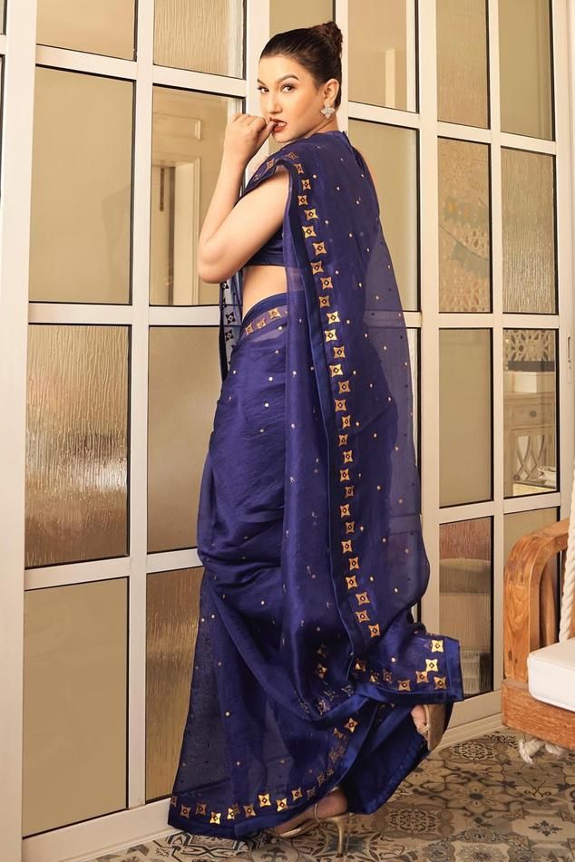 Ink blue saree in silk organza base with all over floral aari embroidery with sequins and zari. Paired with halter neck sleeveless blouse and a petticoat.
Components: 3
Pattern: Embroidery
Type Of Work: Aari Work With Sequins and Zari
Neckline: Halter Neck
Sleeve Type: Sleeveless
Fabric: Saree: Silk Organza, Blouse: Chanderi, Petticoat: Poly Satin
Color: Blue
Other Details: 
Length:
Saree: 5.6-5.75inches
Petticoat: 39inches
Occasion: Wedding, Puja - Aza Fashions Silk Blue Choli With Pallu, Blue Bollywood Saree With Dori Work, Traditional Blue Organza Blouse Piece, Festive Blue Blouse Piece With Sheer Dupatta, Blue Designer Saree With Dori Work, Navratri Blue Silk Blouse Piece, Blue Dori Work Saree For Eid, Blue Organza Dupatta In Traditional Drape, Indigo Dupatta With Pallu For Wedding