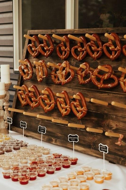 an assortment of pretzels are on display at a wedding or reception table with cupcakes