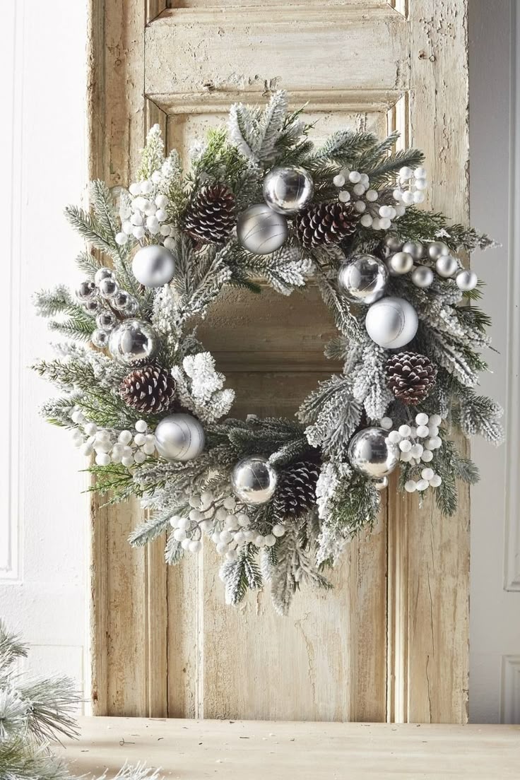 frosted pine wreath with shiny and matte silver balls, frosted pinecones and white berry picks White Pinecone Wreath, Christmas Wreaths Silver, Silver Wreath Christmas, Decorate Christmas Wreath, White Christmas Wreath Ideas, Christmas Wreaths White, Silver Christmas Wreaths, Silver Pinecones, Silver Wreaths