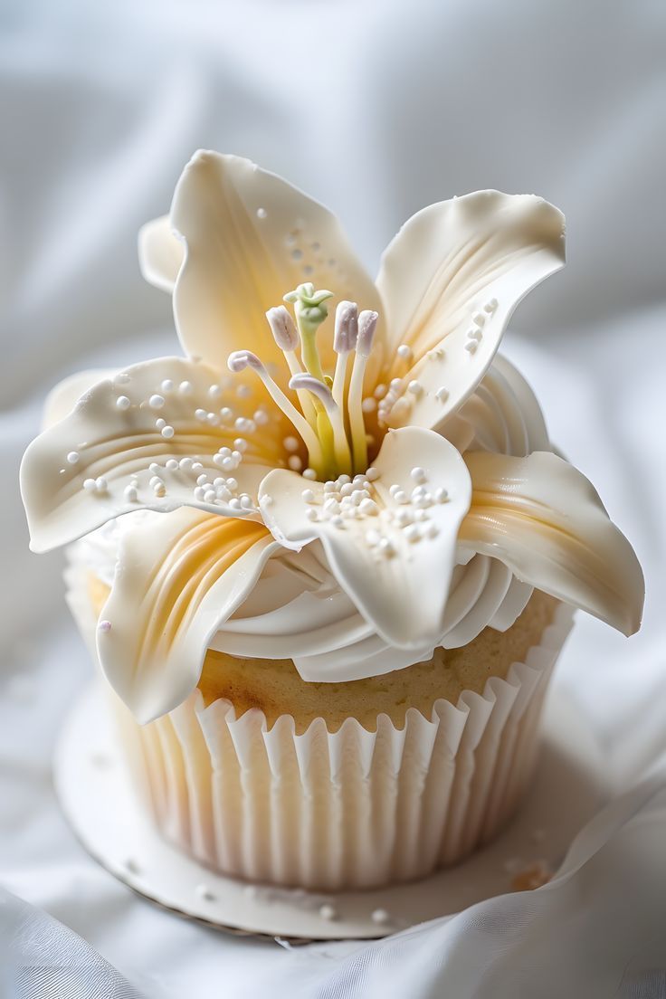 a cupcake with white frosting and a flower on top