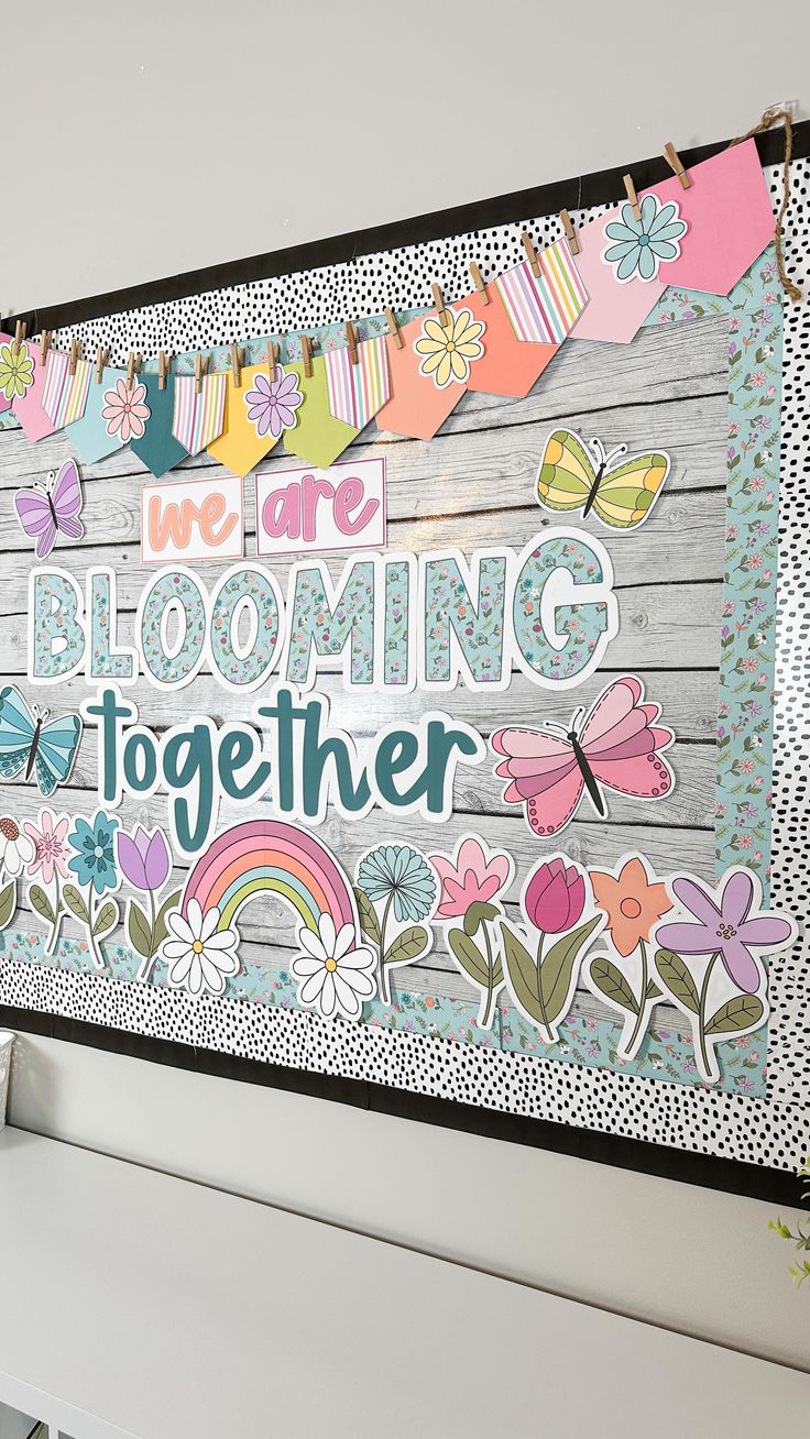 there is a sign on the wall that says we are blooming together with flowers and butterflies