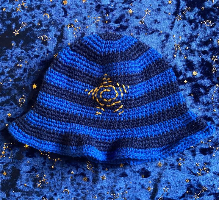 a blue and black knitted hat laying on top of stars