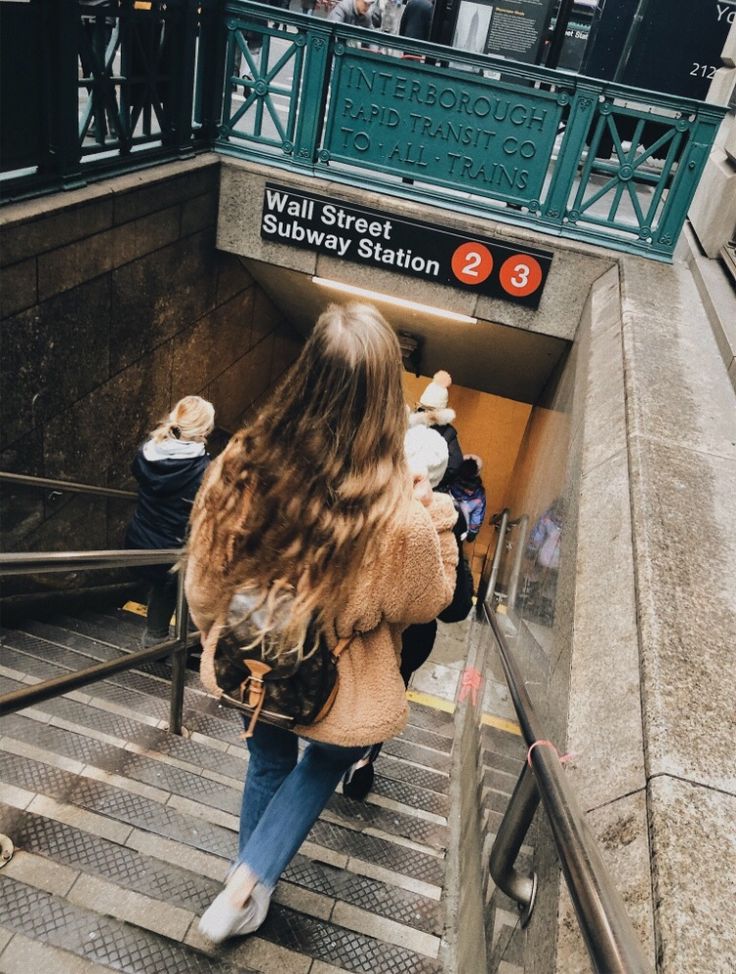 a woman is walking up some stairs