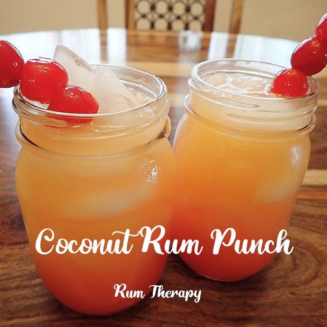 two mason jars filled with drinks sitting on top of a wooden table