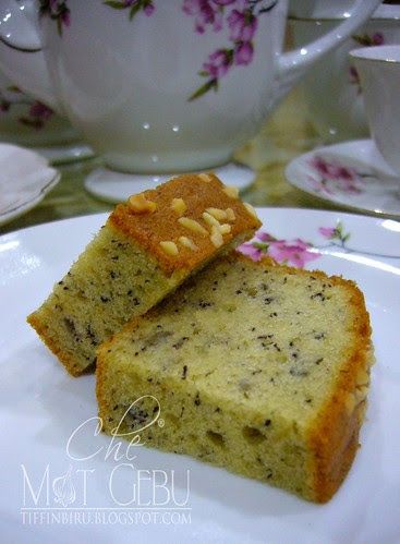 two pieces of cake sitting on top of a white plate next to cups and saucers