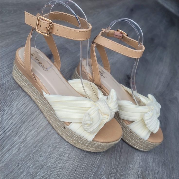 Beige/Cream Sandal With Satin Feel Bow Across Top Bamboo Brand Infinity Style. P/U Ankle Strap With Soft Fabric Bow Strap Across Foot. Perfect Sandals To Wear To All Your Spring Time Functions. Extremely Comfortable Sandal That’s Easily Wearable For All Ages. Tts Approx 1” Height Platform New In Box Adjustable Cream Wedge Heel Sandals, Cream Adjustable Wedge Heel Sandals, Beige Synthetic Wedge Sandals With Round Toe, Cream Round Toe Sandals For Beach Season, Cream Round-toe Sandals For Beach Season, Beige Synthetic Round Toe Wedge Sandals, Beige Adjustable Wedge Sandals With Cushioned Footbed, Adjustable Cream Platform Sandals, Cream Synthetic Sandals For Beach Season