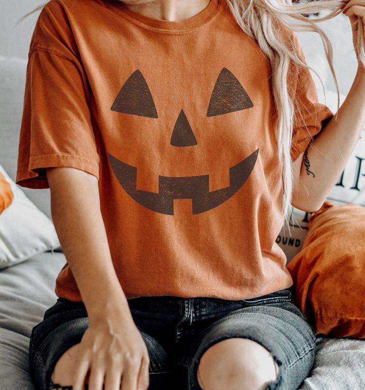 Retro Pumpkin Face Tee Shirt, Vintage Funny Jack O Lantern Halloween Tshirt The Comfort Colors C1717 100% Ring Spun Cotton T-Shirt is very appropriately-named. All colors are inspired by nature and have a perfect lived-in, weathered look. Shirts are sent through a unique dyeing process that makes them incredibly soft and long-lasting. Each piece is soft-washed 50 times before making its way to you! Stitched at the collar, armhole, sleeves and bottom hem for ultimate durability, you will notice the density and quality of this shirt, but won't mind living in it. COMFORT COLORS 1717 ADULT TEE 6.1 Oz/SqYd 100% Ring Spun Cotton Soft-washed garment-dyed fabric Double-needle collar Twill taped neck and shoulders Twill label Relaxed fit Double needle armhole, sleeve and bottom hems Tubular body PR Pumpkin Face Tshirt, Cotton Halloween Shirt, Spooky Orange T-shirt For Fall, Spooky Pre-shrunk T-shirt For Fall, Casual Orange Tops For Halloween, Spooky Short Sleeve T-shirt For Fall, Spooky Orange Crew Neck Top, Orange Crew Neck Top For Halloween, Orange Crew Neck T-shirt For Fall