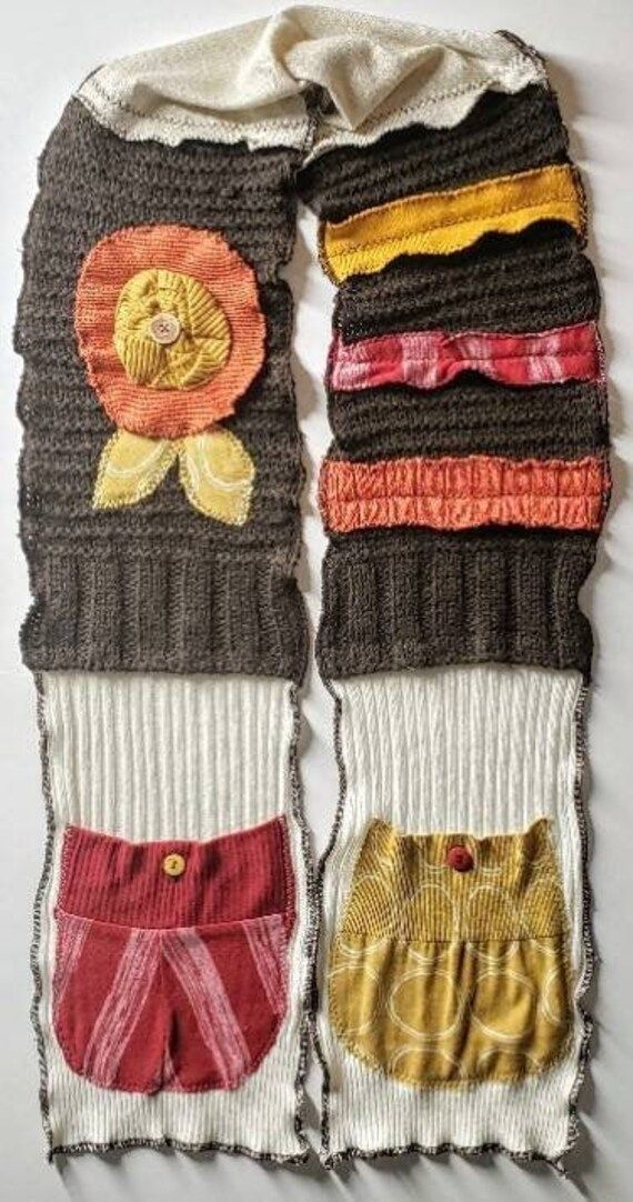 two pieces of knitted clothing with different colors and designs on them, one has a flower in the middle