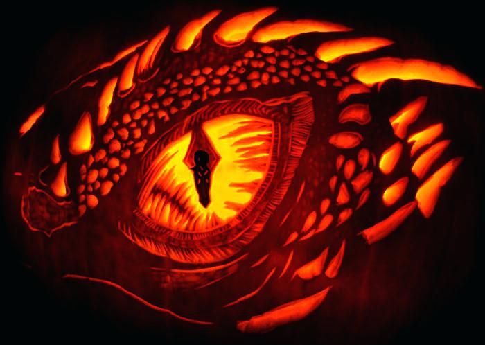 a carved pumpkin with an image of a dragon's eye in the middle of it