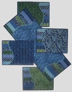 four blue and green quilted placemats are arranged in the shape of squares