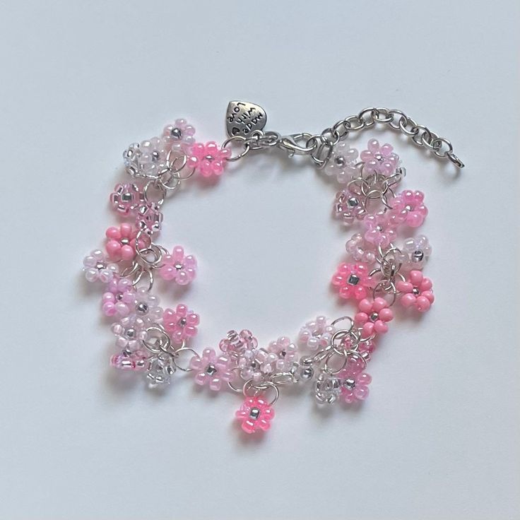 "A sweet handmade bracelet ✿ Made with glass seed beads and silver accents ✿ An assortment of pinks, bubblegum, blush, rose, milky white, and silver ✿ The bracelet has an additional 1-1.5\" of extension chain" Pink Flower-shaped Beaded Charm Bracelet, Adjustable Pink Beaded Bracelet With Silver Beads, Pink Flower Charm Bracelet For Jewelry Making, Pink Nickel-free Charm Bracelet, Adjustable Pink Jewelry With Silver Beads, Pink Hypoallergenic Beaded Bracelets, Pink Beaded Flower Charm Bracelet, Pink Beaded Charm Bracelet, Pink Bracelets With Flower Charm And Round Beads