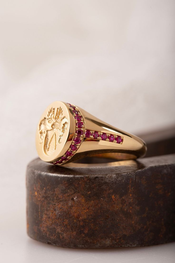 A family crest signet ring that can be personalized with your own crest. We can set different gemstones instead of diamonds, such as red ruby, blue sapphires, green emerald or a combination. Gemstones: Natural Ruby 0.66ct VSGH1 *real images of the ring, taken by us* Face Size: 15x13mm Material: - Sterling Silver (925) - 9K Gold (375) - 14K Gold (585) - 18K Gold (750) *All signet rings are hallmarked on the back for certification* - We offer FREE Worldwide DHL & FedEx Shipping! - Branded Danelian Luxury Red Intaglio Signet Ring, Signet Rings Family Crest, Luxury Red Signet Ring For Wedding, Family Crest Signet Ring, Signet Ring With Gemstones, Signet Diamond Ring, Heirloom Ruby Signet Ring With Hallmark, Heirloom Ruby Signet Ring With Polished Finish, Luxury Ruby Signet Ring Hallmarked