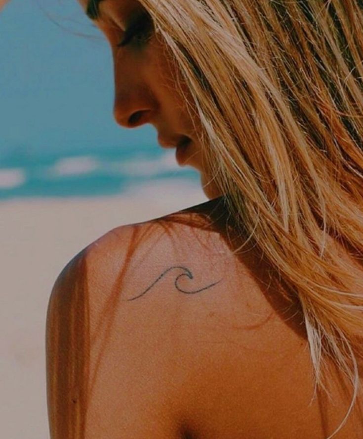 a woman with a wave tattoo on her back