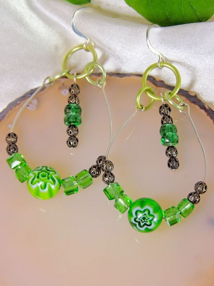 Playful & light boho beaded teardrop earrings featuring green millefiori focal bead focals. These earrings are also accented with beautiful Czech glass crystals antiqued silver filigree ball beads. Carefully hand shaped & beaded These earrings can be dressed up or down for easy styling with any outfit! ✿ Aluminum rings, antiqued silver balls, stainless steel wire, glass millefiori beads, glass crystal cubes, faceted Czech glass crystals ✿ 2.5" long earrings from top of earwires ✿ Boho hippie chi Green Teardrop Hoop Earrings, Green Glass Dangle Jewelry, Green Teardrop Metal Earrings, Hypoallergenic Teardrop Glass Jewelry, Nickel-free Teardrop Glass Jewelry, Nickel-free Glass Teardrop Jewelry, Green Beaded Teardrop Jewelry, Green Beaded Dangle Teardrop Earrings, Glass Jewelry With Dangling Beads