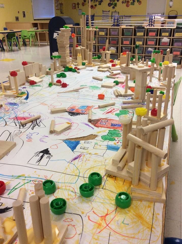 an art room with wooden toys and colored paper on the floor