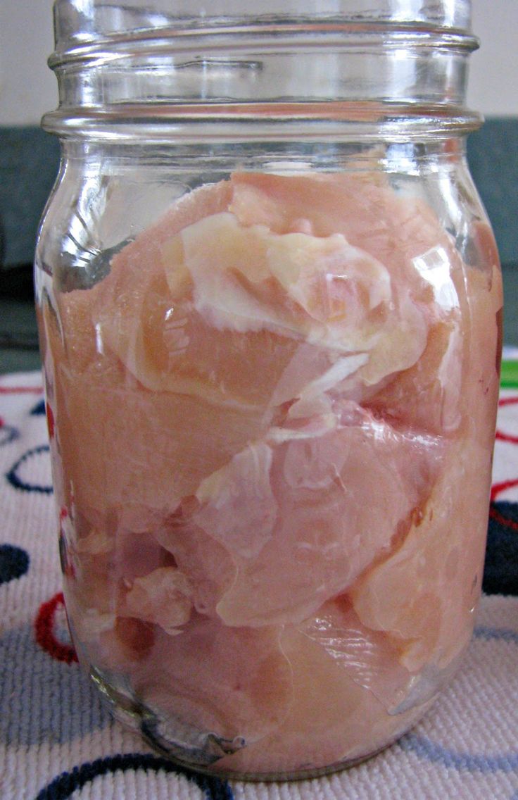 a jar filled with raw meat sitting on top of a tablecloth covered floor next to a rug