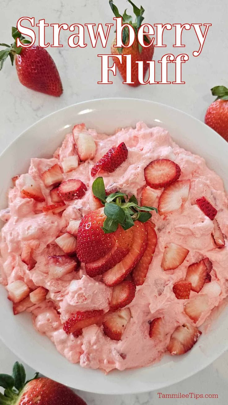 strawberry fluff in a bowl with strawberries on the side