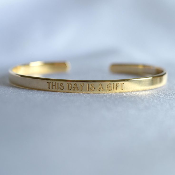 You can engrave this quote or any other text on our gold-plated timeless bracelet. - Narrow bracelet engraved with your chosen message. - The  thickness of gold plating is around 0.5 microns - Text, coordinates, numbers or handwriting outside and inside the cuff  - Up to 90 characters  on each side - Approximately 5mm wide, 16cm long This personalised gold plated bangle will make the perfect gift for mum, sister, grandma, bridesmaid or any other loved one in your life. SIZES: This is the length of the metal, not including the opening between the ends. The bracelets are adjustable. 4" (baby/toddler size) 5" (child size) 6.3" (standard - fits MOST adults) 7" (popular for men) With an elegant radiance to captivate the eyes, this gold-plated cuff will make you stand out from the crowd! Colors Gift Gold Etched Cuff Bracelet, Minimalist Bracelets With Engraving Option For Gifts, Engraved Name Bangle Bracelet As Gift, Classic Etched Bracelets As Gift, Classic Etched Bracelets As A Gift, Everyday Spiritual Engraved Bracelets, Inspirational Engraved Text Bracelets For Gifts, Gold Minimalist Cuff Bracelet For Friendship, Gold Cuff Bracelet With Engraving Option